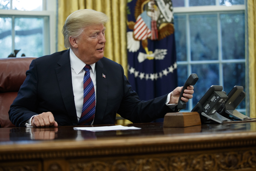 President Donald Trump hangs up after talking with Mexican President Enrique Pena Nieto on the phone in the Oval Office of the White House on Monday.