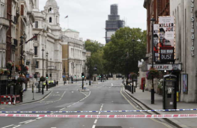 A deserted road leading to the scene where a car crashed into security barriers outside the Houses of Parliament to the right of a bus in London, Tuesday, Aug. 14, 2018. London police say that a car has crashed into barriers outside the Houses of Parliament and that there are a number of injured.