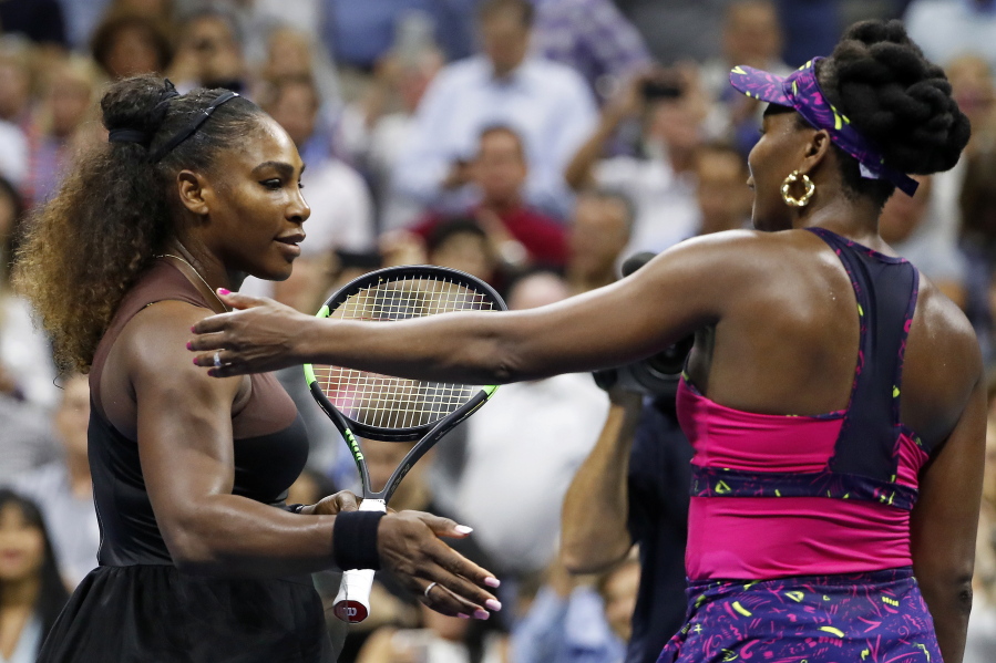 Serena Williams, left, meets her sister Venus Williams after their match during the third round of the U.S. Open tennis tournament, Friday, Aug. 31, 2018, in New York. Serena Williams won 6-1, 6-2.