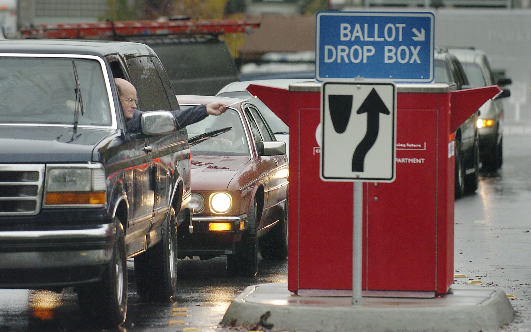 A steady stream of cars visits the ballot drop box at West 14th and Esther streets every major election. With ballots now including prepaid postage, voters do not need to stop by a ballot drop box if they want to return their ballot for free.