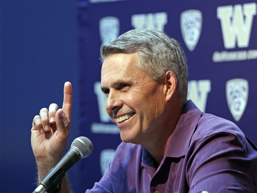 Washington NCAA college head football coach Chris Petersen points skyward in response to hearing Blue Angels jets soar nearby as he speaks at a news conference Thursday, Aug. 2, 2018, in Seattle. Petersen hates expectations, so he’s likely loathing Washington being the overwhelming favorite in the Pac-12 and likely top 10 when the preseason AP poll comes out. The Huskies open fall camp on Friday in preparation for the Sept. 1 opener against Auburn.