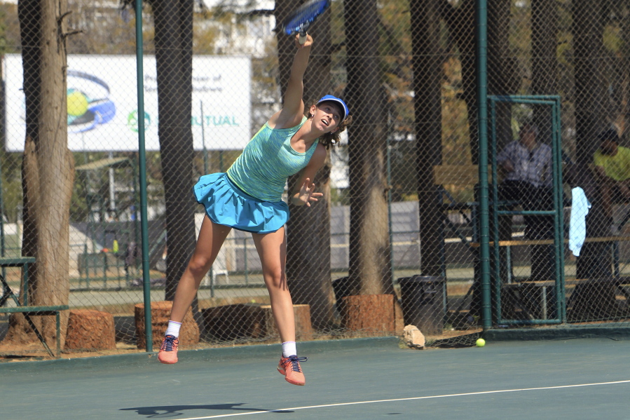 Victoria Sasinka, 13, of the US serves the ball, during an International Tennis Federation Tournament, at Harare Sports Club, in Harare, Monday, Aug. 6, 2018. As Zimbabwean soldiers opened fire on rioters, protesters and bystanders after a disputed election, teen-agers in an International Tennis Federation tournament were battling each other on hard courts a few kilometers (miles) from the deadly violence.