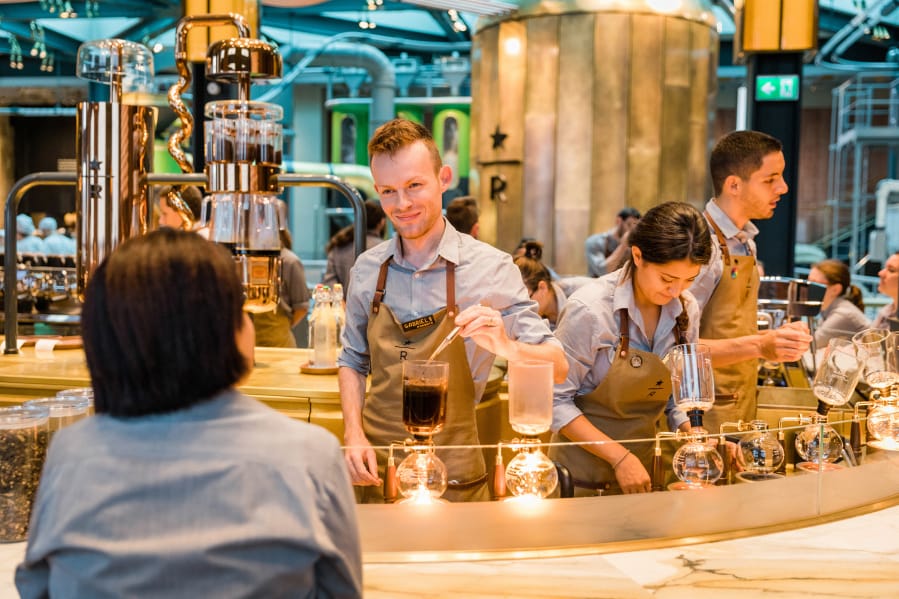Starbucks barista Gabriel Sebastian Denes works at the siphon brewing station at the Starbucks Reserve Roastery in Milan, Italy, on Aug. 2.