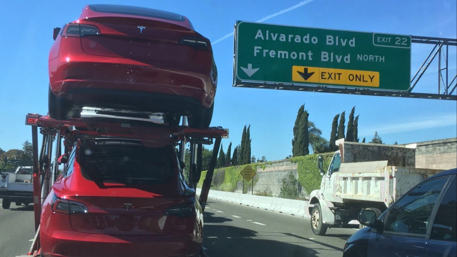 Tesla Model 3 cars are transported on a truck on Interstate 80 in Fremont, Calif.