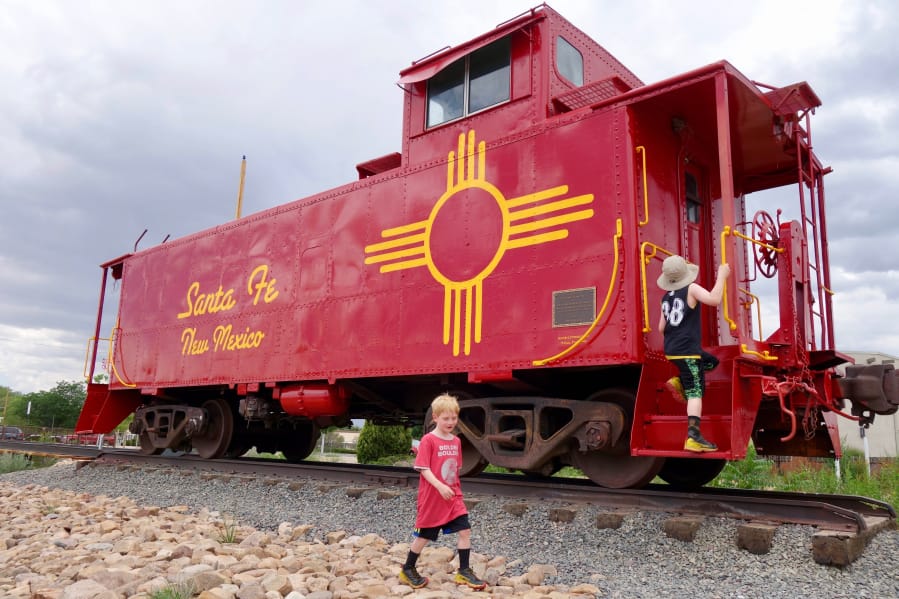 The author’s sons explore an old railcar secured on the tracks at the Railyard, a popular Santa Fe gathering spot.