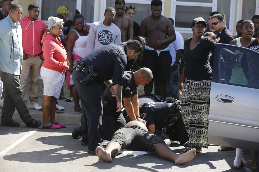 Los Angeles Police Department officers work to revive a resident of Nickerson Gardens after an apparent drug overdose on July 26, 2016.