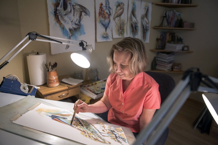 Watercolorist Denise Joy McFadden works on a seabird in her home studio in Cascade Park. She and her husband frequent the Oregon coast to go birding and find subjects for her paintings, she said.