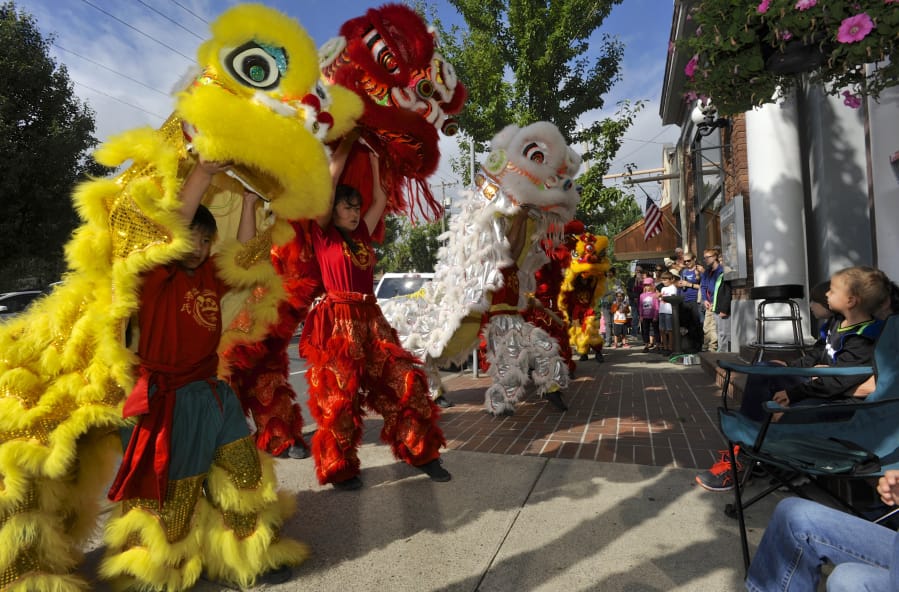 Members of the Portland Lee’s Association Lion and Dragon Dance team march around downtown Ridgefield on Saturday as part of the first Ridgefield Multicultural Festival, which started from an idea from a resident.