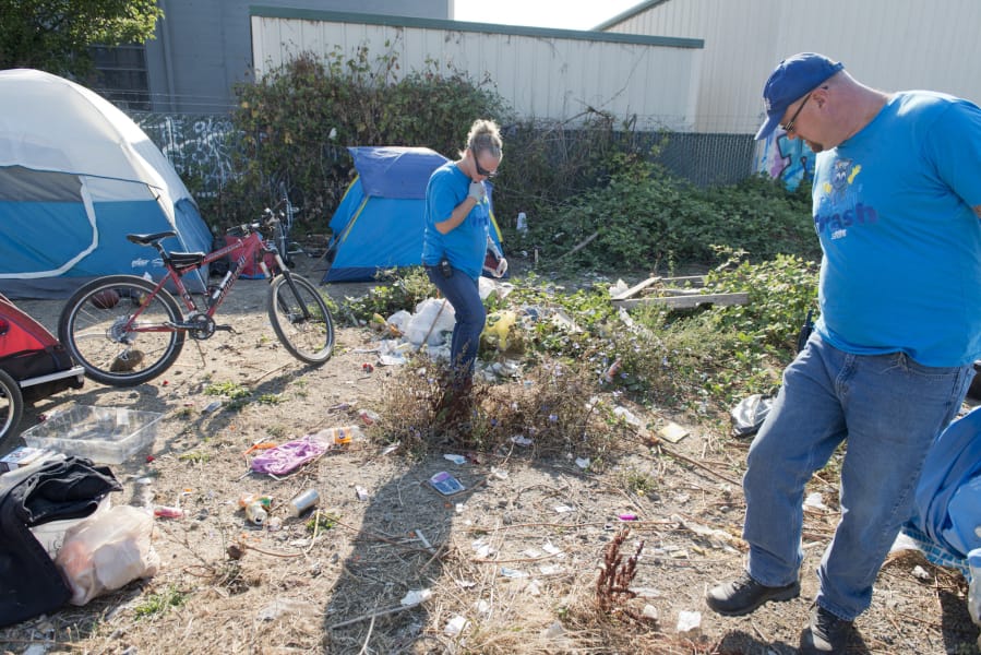 Jennifer Klein and Matt Curry check for needles before cleaning a homeless camp in west Vancouver. The Talkin’ Trash program gives jobs to homeless or formerly homeless people and reduces litter around the city.