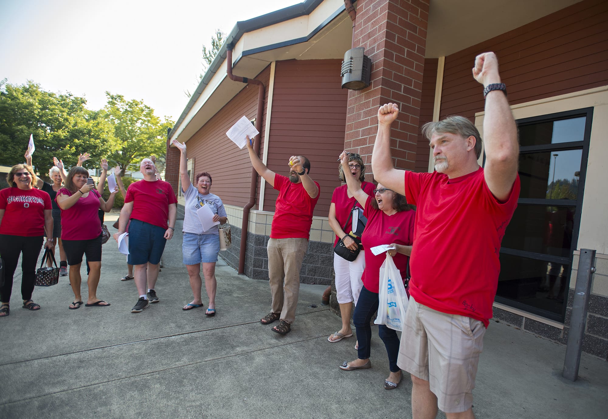 Eric Engebretson, president of the Washougal Association of Teachers, right, celebrates with fellow educators outside Washougal High School after the union unanimously ratified their new contract Thursday morning, Sept. 6, 2018.
