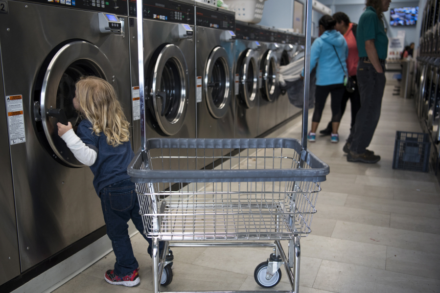 Leo Guerra, 3, peeks in the washer before helping his parents unload laundry at Cedars Laundromat in Woodland on Sept. 11, when the laundromat was hosting its monthly Laundry Love event where people can do laundry for free. The national program was brought to Woodland in April by DeeAnna Holland.