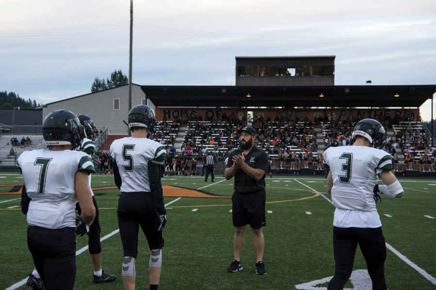 Woodland assistant coach DJ Malinowski talks with the team before its 2A Greater St. Helens League opener at Washougal on Friday.