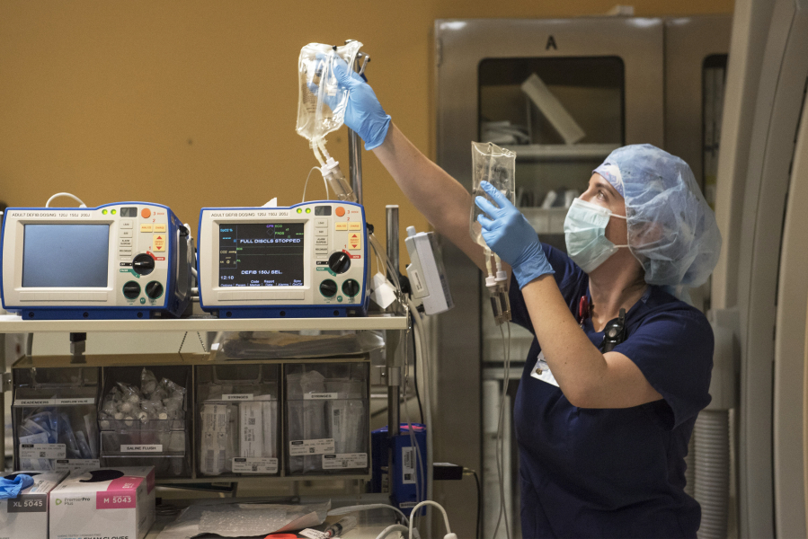 Registered Nurse Kristina Yang of Ridgefield prepares IV lines prior to surgery in a catheterization unit at PeaceHealth Southwest Medical Center in Vancouver.