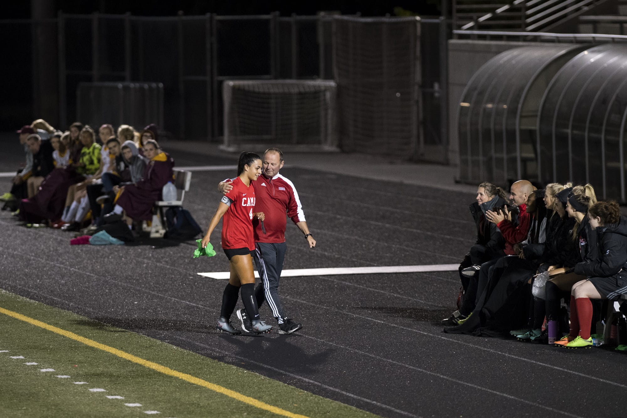 Camas' Maddie Kemp (4) is congratulated by coach Roland Minder after surpassing her 100th career goal mark during Tuesday night's game against Prairie High School at Doc Harris Stadium in Camas on Sept. 18, 2018. Camas won 10-3.