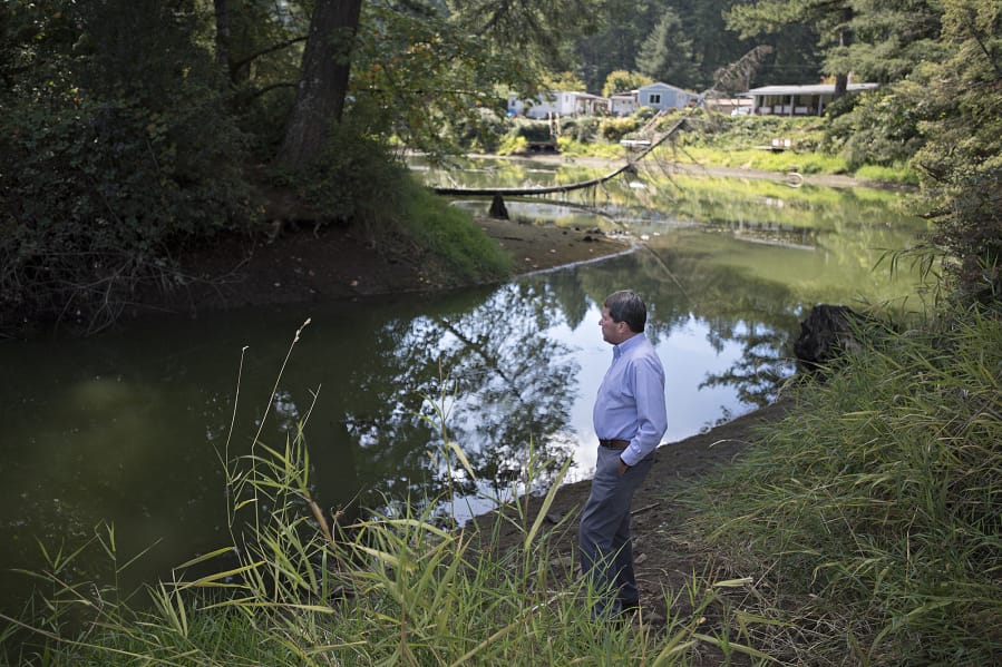 Camas city administrator Pete Capell looks over water that was diverted from Round Lake toward the mill ditch area. Georgia-Pacific recently donated about 181 acres appraised at $960,000 that was owned by the Camas paper mill to the city to be used for green space and recreation. Top: The dam at Lacamas Park, which was recently donated to the city of Camas from Georgia-Pacific, is seen Thursday during the annual partial draining of Round Lake for maintenance work.