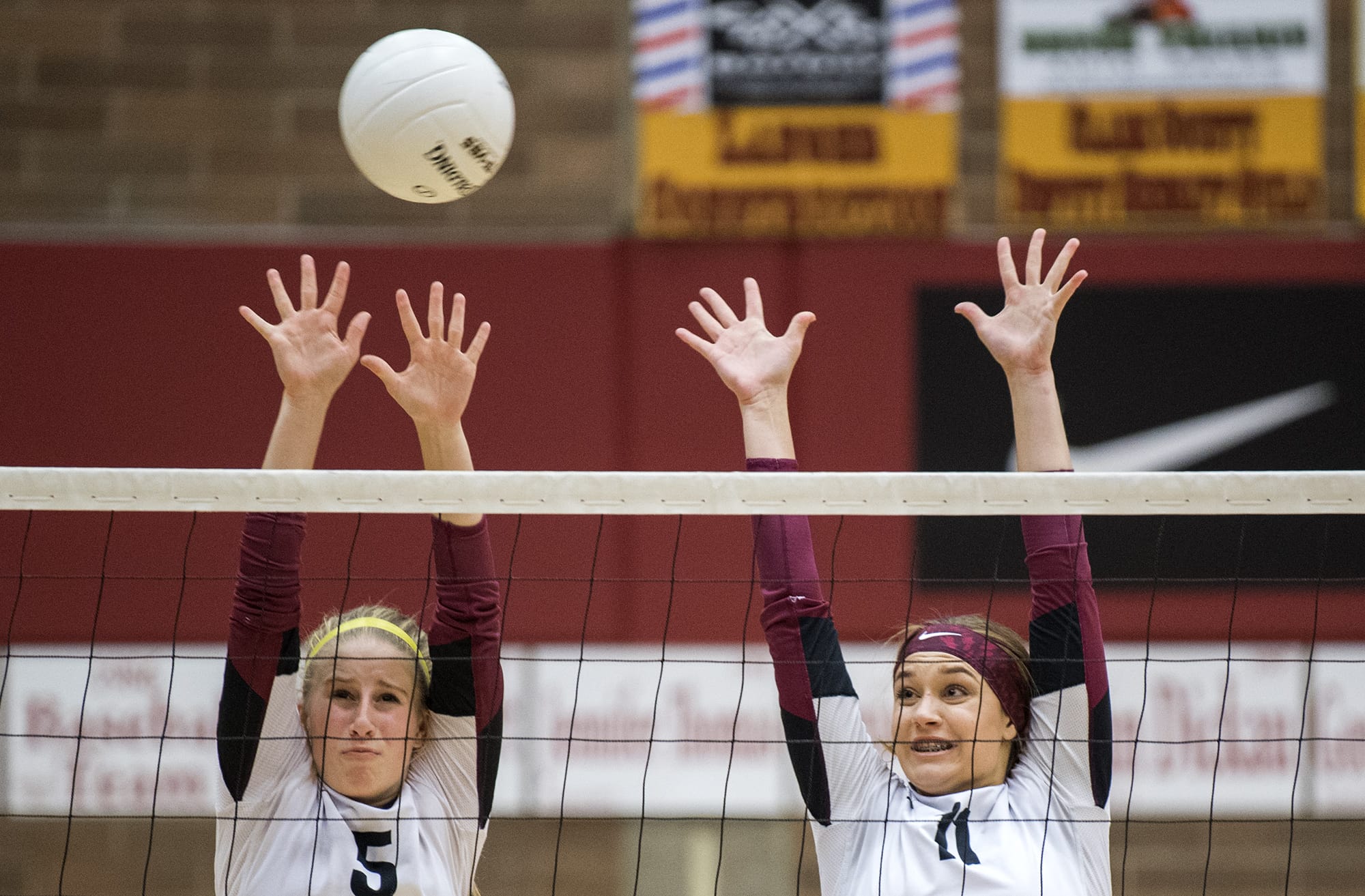 Prairie's Jamie Packer (5) and Amelia Renner (11) jump to block a spike during Tuesday night's game against Kelso at Prairie High School in Camas on Sept. 25, 2018.