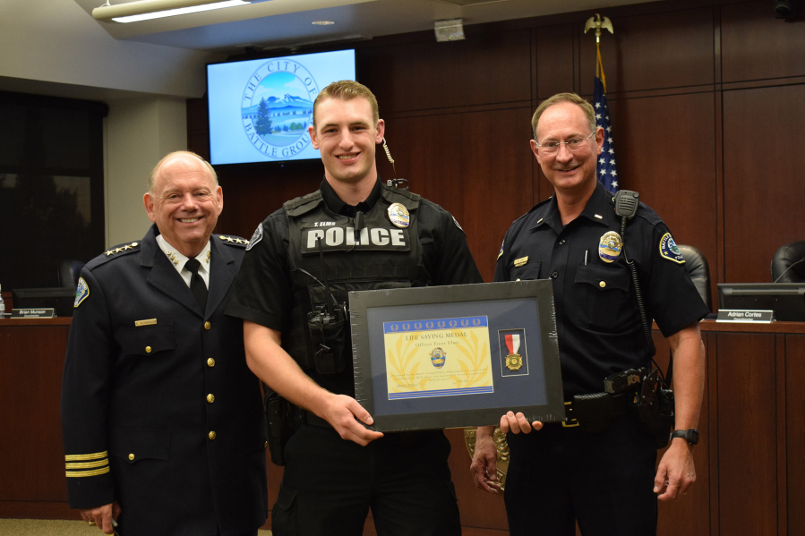 Battle Ground police Chief Bob Richardson, from left, Officer Trent Elms and Lt. Mike Fort at a ceremony honoring Elms for saving a man’s life in February.