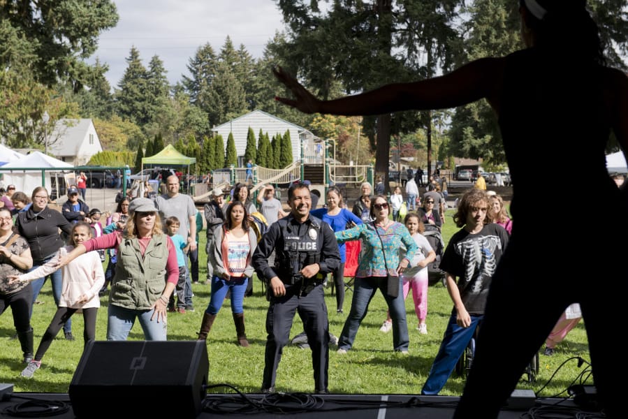 Vancouver police officer Gerardo Gutierrez, a Mountain View High School resource officer, practices salsa dance steps along with the rest of the crowd Saturday during a group lesson with the Bachata Soul Dance Company in Vancouver’s Evergreen Park.