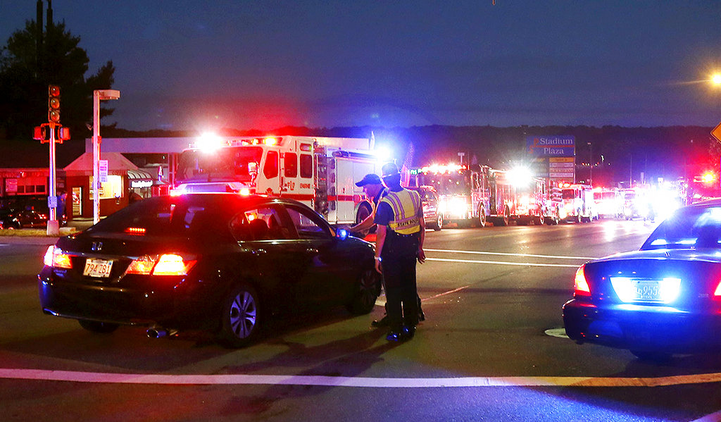 Police officers man a checkpoint as multiple fire trucks from surrounding communities are staged along a road Thursday, Sept. 13, 2018, in Lawrence, Mass. A problem with a gas line that feeds homes in several communities north of Boston triggered a series of gas explosions and fires.