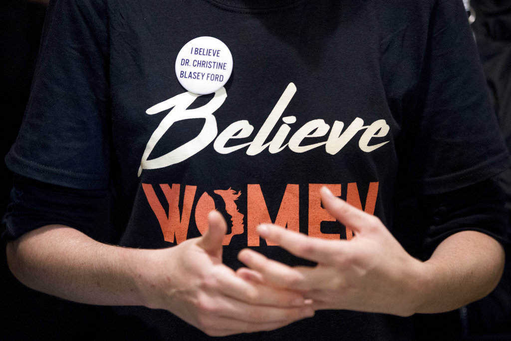 A woman wears a shirt that reads "Believe Women" with a button that reads "I Believe Dr. Christine Blasey Ford" as protesters against Supreme Court nominee Brett Kavanaugh tell their personal stories of sexual assault outside offices of Sen. Jeff Flake, R-Ariz., on Capitol Hill in Washington, Monday, Sept. 24, 2018, as the Senate begins a week of scrutiny of President Donald Trump's nominee to the high court. Judge Brett Kavanaugh's nomination to the U.S. Supreme Court has been further imperiled by a second sexual-misconduct allegation, dating to his first year at Yale University.