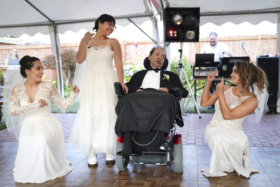 Akhil Jhaveri, center, watches as his three daughters, Jordan Jhaveri, left, Ashley Jhaveri and Corinne Jhaveri dance around their father July 30 during an honorary wedding at Vintage Gardens in Ridgefield. He asked for the wedding as a final wish. He died Saturday at age 52.