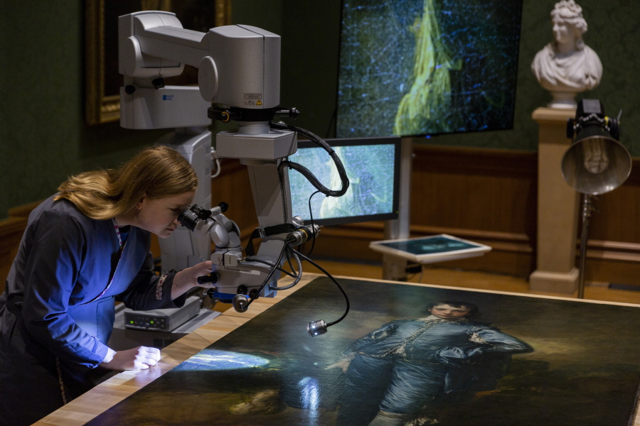 Huntington paintings conservator Christina O’Connell examines Thursday “The Blue Boy,” made around 1770 by English painter Thomas Gainsborough, through a surgical microscope at The Huntington in San Marino, Calif.