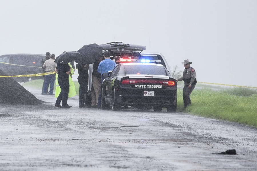 Law enforcement officers gather near the scene where the body of a woman was found near Interstate 35 north of Laredo, Texas on Saturday, Sept. 15, 2018. A U.S.