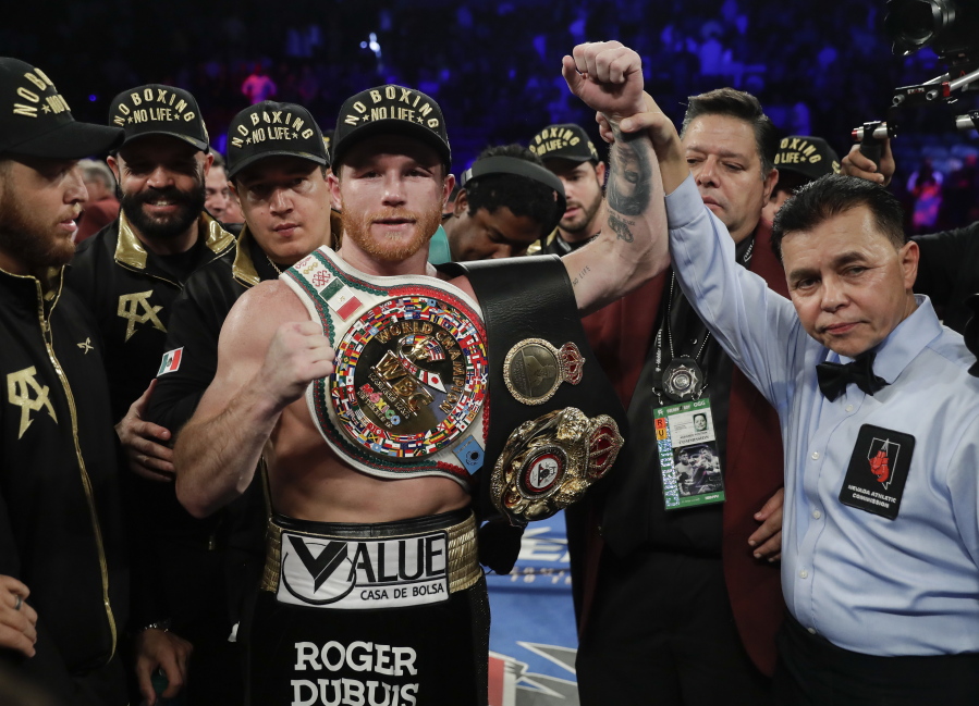 Canelo Alvarez poses for a photo with referee Benjy Esteves Jr., right, after defeating Gennady Golovkin by majority decision in a middleweight title boxing match, Saturday, Sept. 15, 2018, in Las Vegas.