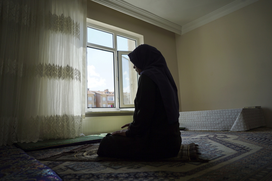 In this Aug. 20, 2018, photo, Meripet, 29, prays at her home in Istanbul, Turkey. Meripet came to Turkey in February 2017 to visit her sick father, leaving four children behind. While in Turkey, she heard Uighur passports were being seized and that people who had gone abroad were being taken to reeducation, so she stayed in Turkey, giving birth to Abduweli. She hasn’t seen her other four children since, and heard they were taken to a live-in kindergarten in Hotan, China.
