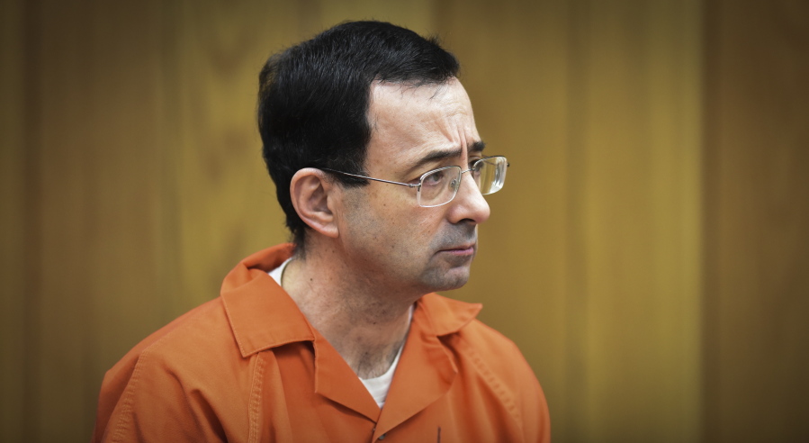 FILE - In this Feb. 5, 2018 file photo, Larry Nassar, former sports doctor who admitted molesting some of the nation’s top gymnasts, appears in Eaton County Court in Charlotte, Mich. Numerous people have been criminally charged, fired or forced out of jobs in the wake of the scandal involving once-renowned gymnastics doctor, Nassar, who is serving decades in prison for molesting athletes and for child pornography crimes.