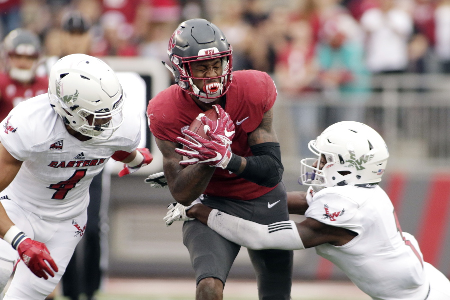 Eastern Washington defensive back Mitch Fettig (4) and defensive back Josh Lewis, right, tackle Washington State wide receiver Davontavean Martin during the first half of an NCAA college football game in Pullman, Wash., Saturday, Sept. 15, 2018.
