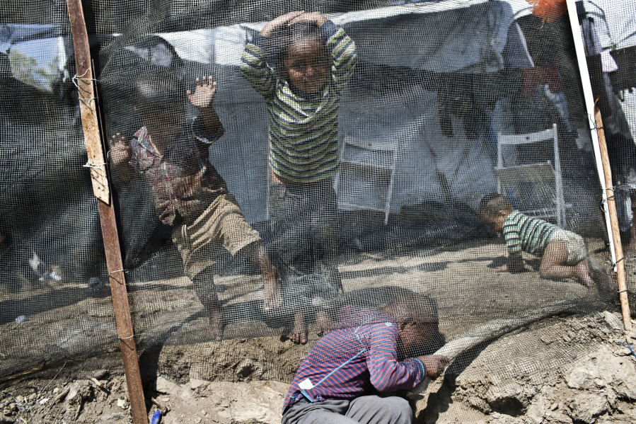 FILE - In this Wednesday, May, 2, 2018, file photo, children play inside the Moria refugee camp on the northeastern Aegean island of Lesbos, Greece. The jammed Moria camp on the Greek island of Lesbos and the dangerous migrant detention centers in Libya serve as a sober reminder to European leaders that their statistical success in curbing migration into the continent has spawned what the U.N. and others condemn as massive humanitarian failures. Deeply divided over how and where to control Europe’s borders, leaders are meeting Wednesday, Sept. 19, 2018 in a summit in Austria.