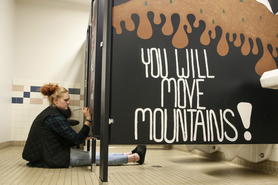 Madison Smith paints a stall in the girls room Tuesday afternoon at Crossroads High School in Granite Falls, Wash. on Tuesday, Sept. 11, 2018.