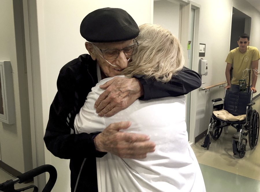 The Rev. John Sabbagh, left, and his son Ebby Sabbagh hugs nurse practitioner Kim O’Riley, Friday, Sept. 7, 2018 in Gilbert, Ariz. Thirty-five years after a Mesa man cared for his son when he was shot in their native Lebanon, the son is returning that devotion. Both the Rev. John Ibraham Sabbagh and his 54-year-old son, Ebby Sabbagh, are celebrating one year of going strong since the elder Sabbagh received a crucial stem-cell transplant.
