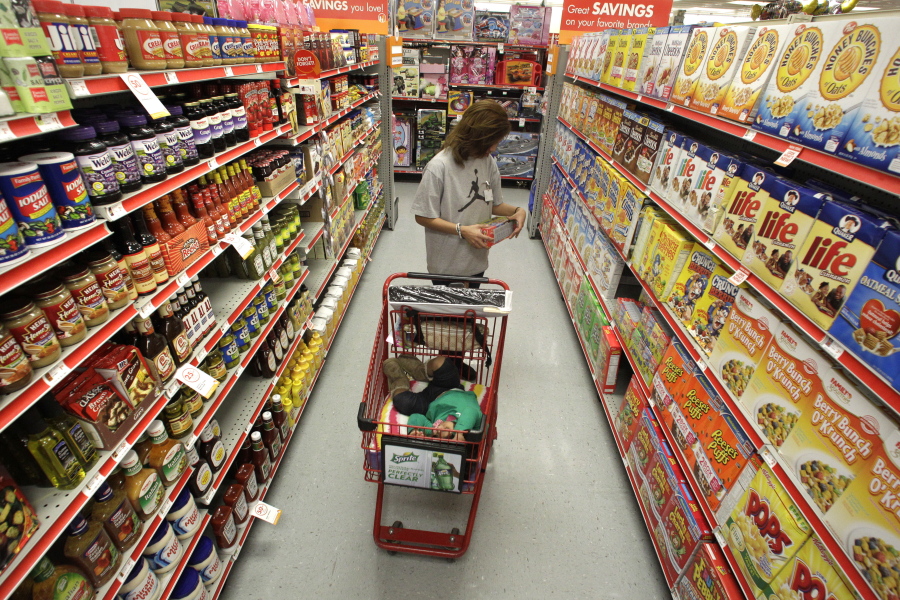 FILE - In this Dec. 14, 2010, file photo, Alicia Ortiz shops through the cereal aisle as her daughter Aaliyah Garcia catches a short nap in the shopping cart at a Family Dollar store in Waco, Texas. Don’t be intimidated by the idea of a weekly big supermarket shop. Buying a lot in one fell swoop helps keep your kitchen organized and well-stocked all week.