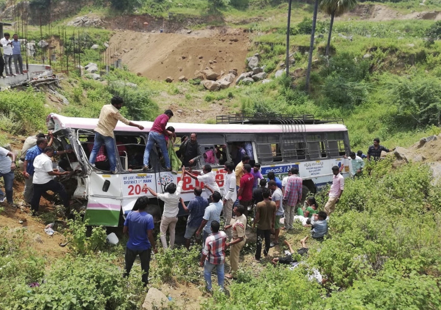 Rescuers pull out passengers from a bus that fell into a gorge in Jagtiyal district of Telangana, India, on Tuesday. A bus carrying pilgrims from a Hindu temple in the hills of south India plunged off a road Tuesday, killing more than 50 people including four children, officials said.