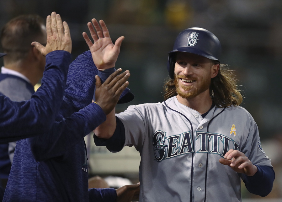 Seattle Mariners’ Ben Gamel is congratulated after scoring against the Oakland Athletics during the fifth inning of a baseball game Saturday, Sept. 1, 2018, in Oakland, Calif.