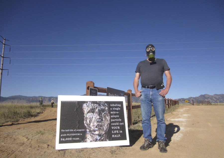 Stephen Parlato wears a gas mask next to his sign warning about the dangers of plutonium at Rocky Flats National Wildlife Refuge outside Denver on Saturday, the first day the refuge was open to the public. The refuge is on the outskirts of a former U.S. government factory that manufactured plutonium triggers for nuclear weapons.