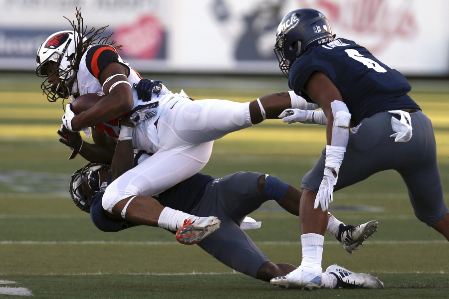 Oregon State’s Christian Wallace (29) catches a first down pass in front of Nevada’s Jomon Dotson (23) and Nephi Sewell (6) during the second half of an NCAA college football game, Saturday, Sept. 15, 2018, in Reno, Nev.