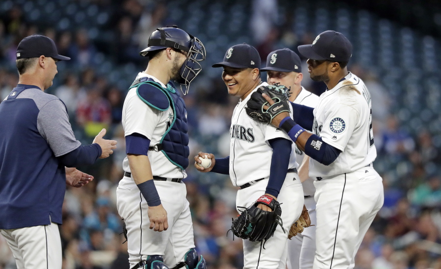 Seattle Mariners starting pitcher Erasmo Ramirez, center, smiles while being relieved against the Baltimore Orioles in the sixth inning of a baseball game Monday, Sept. 3, 2018, in Seattle.