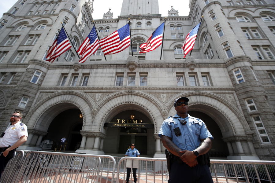 FILE - In this June 30, 2018, file photo, aw enforcement officers stand guard in front of the Trump Hotel in Washington. A federal district judge in Washington says a group of nearly 200 Democratic senators and representatives has legal standing to sue President Donald Trump to prove he violated the U.S. Constitution's emoluments provision.