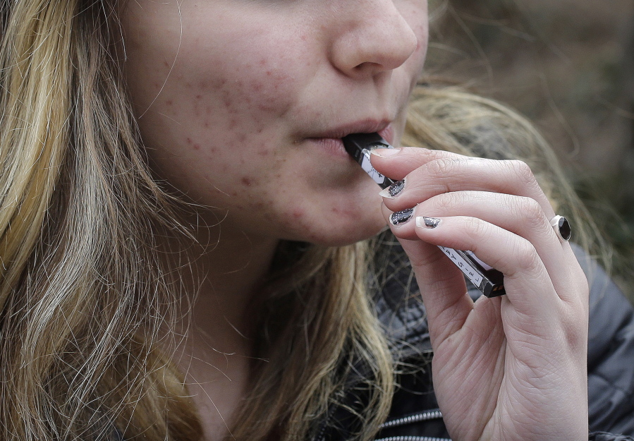 An unidentified 15-year-old high school student uses a vaping device near the school’s campus in Cambridge, Mass. A school-based survey shows nearly 1 in 11 U.S. students have used marijuana in electronic cigarettes, heightening concern about the new popularity of vaping among teens. E-cigarettes typically contain nicotine, but results published Monday, Sept. 17, mean a little more than 2 million middle and high school students have used the devices to get high.