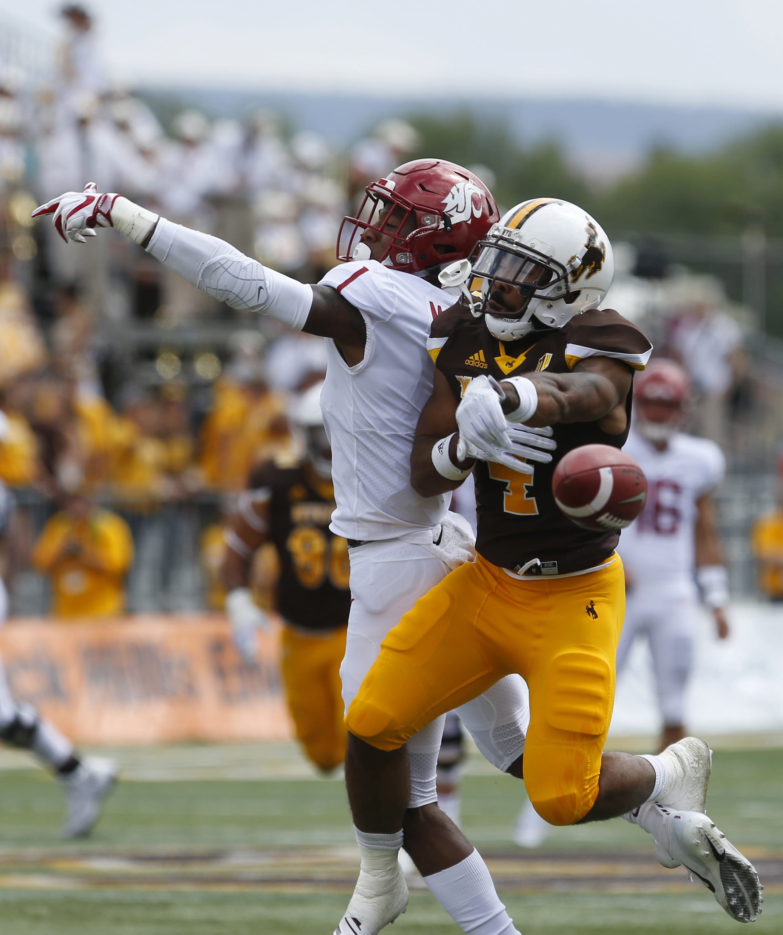 Wyoming's Antonio Hull, right, breaks up a pass intended for Washington State's Tay Martin during an NCAA college football game Saturday, Sept. 1, 2018, in Laramie, Wyo. Washington State defeated Wyoming 41-19.