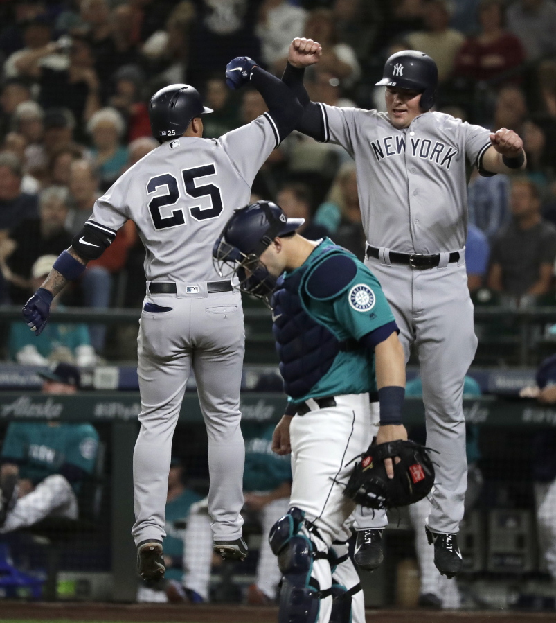 New York Yankees’ Gleyber Torres, left, jumps to celebrate with Luke Voit, right, above Seattle Mariners catcher Mike Zunino after Torres hit a two-run home run to score Voit during the second inning of a baseball game Friday, Sept. 7, 2018, in Seattle. (AP Photo/Ted S.