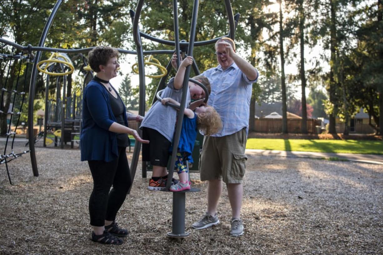 Erin Maher, left, and her husband, Brandon, right, play with their children Liam, 4, left, and Illianna, 22 months, at Cascade Park in Vancouver.