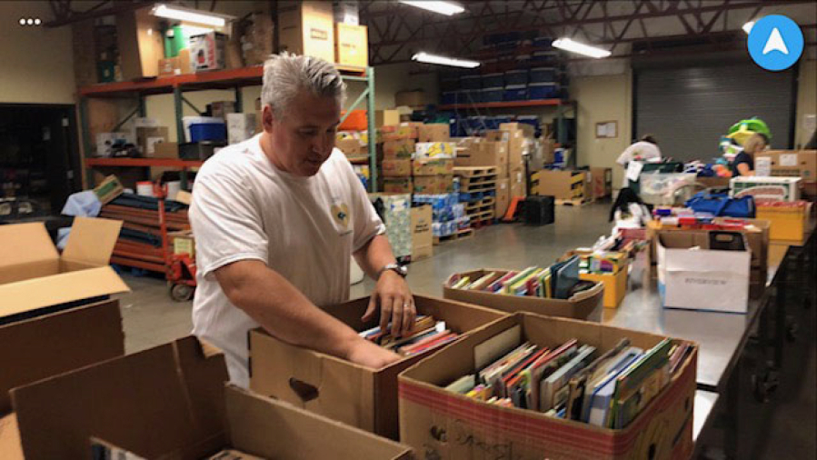 Northeast Hazel Dell: John Cameron organizing books for school shopping day at Share as part of D.A. Davidson Day.