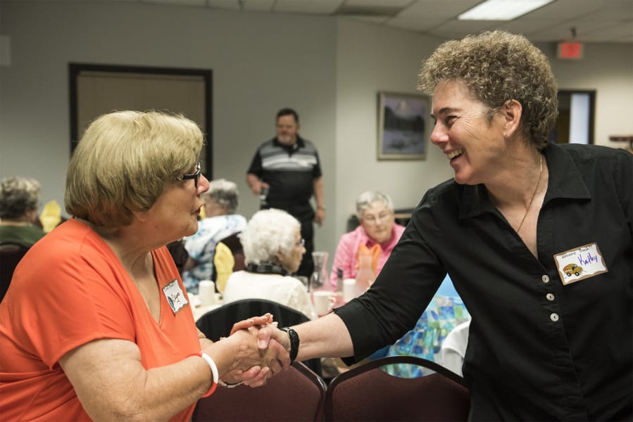 Democratic candidate Kathy Gillespie gives a grin and handshake to Despo Varkados at a Washington State School Retirees’ Association event at Cascadia Tech Academy.
