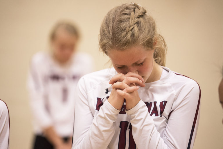 King's Way's Bridgette Young prays for a member of the crowd that was struck by a ball and injured during a game against La Center at King's Way Christian School on Tuesday night, Oct. 2, 2018.