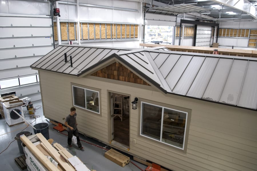 Wolf Industries employees work on one of the tiny modular homes at the company’s new shop in Battle Ground. The company, started by Battle Ground High School grad Derek Huegel, has grown since switching over to building tiny homes full time in 2016, and was recently hired by the nonprofit Homes for Sonoma to build and ship tiny homes to California to help families displaced by wildfires.