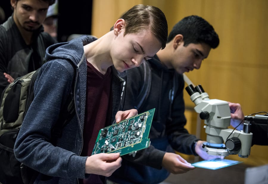 Cody Wold, senior at Evergreen High School, checks out circuit boards at the Silicon Forest Electronics booth during Manufacturing Day at Clark College on Tuesday.